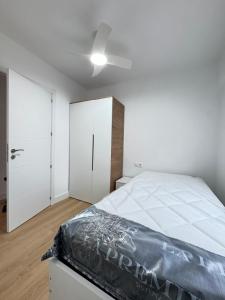 a white bedroom with a bed and a closet at Nohe in Cuenca +11 photos