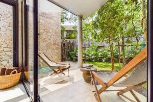 a patio with a couple of chairs and a table at Boho Jungle Villa -Pvt Pool -Concierge-Hammock 7B in Tulum +34 photos