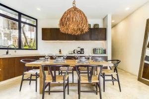 a dining room with a wooden table and chairs at Boho Jungle Villa -Pvt Pool -Concierge-Hammock 7B in Tulum