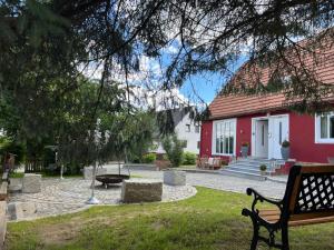 a bench in front of a red and white house at Landhaus 1868 in Villenbach