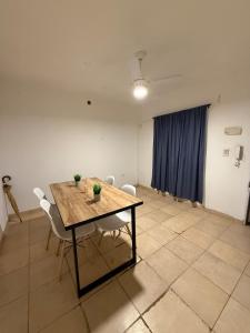 a room with a table and chairs and a blue curtain at Departamento Ideal en zona céntrica de resistencia, chaco in Resistencia