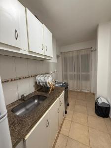 a kitchen with a sink and white cabinets at Departamento Ideal en zona céntrica de resistencia, chaco in Resistencia