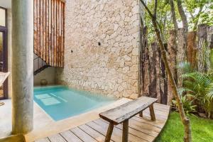 a swimming pool with a bench on a deck at Boho Jungle Villa -Pvt Pool -Concierge-Hammock 7B in Tulum