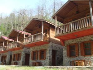 a large wooden house with balconies on top of it at Mencuna Konaklari in Arhavi
