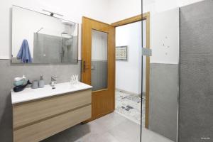 un bagno con lavandino, specchio e doccia di Sofia's Casita ad Alghero Altre 35 foto