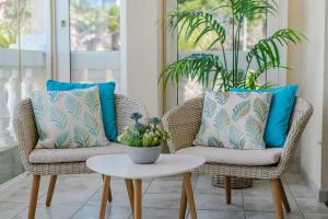 two chairs and a table on a porch with blue pillows at Ocean Terrace Apartment in Los Cristianos