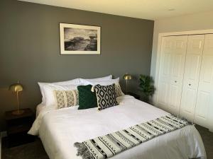 a bedroom with a large white bed with pillows at Spacious Drumheller-RetreatMuseum & Golf in Drumheller