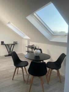 a table and chairs in a room with a skylight at Apartment Weitblick in Wuppertal