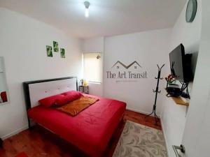 a bedroom with a red bed and a sign on the wall at The Art Transit Aeropolis in Gaga Lima +4 photos