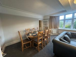 a dining room with a table and chairs and a couch at Cil-y-Coed in Dolgellau