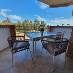 a patio table and two chairs on a balcony at Casa Dorada Primera Línea Oropesa in El Borseral