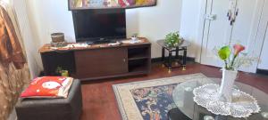 sala de estar con TV y mesa de cristal en Alojamiento Yanira, en Valparaíso