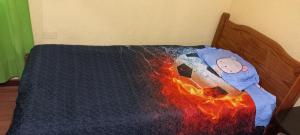 Un juguete infantil en una cama con una manta de fuego en Alojamiento Yanira, en Valparaíso