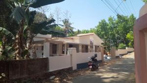 a house with a motorcycle parked in front of it at TROPICAL Villa WITH A VIEW in Vennikulam