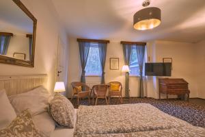 a bedroom with a bed and a table and chairs at Penzión MALINO in Ružomberok