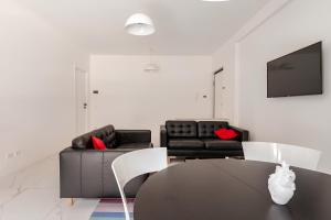 a living room with two black couches and a table at Latina Modern Apartment in Latina