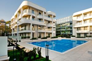 a building with a swimming pool in front of a building at Hotel LIDO in Jurata