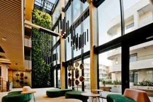 a lobby with green chairs and a building at Hotel LIDO in Jurata