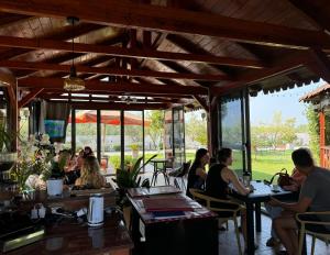 a group of people sitting at tables in a restaurant at KuneVain Guest House in Lezhë