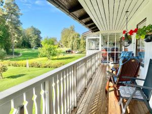 a porch with two rocking chairs and a view of a yard at Ferienhaus mit Sauna nah zum Bade- und Angelsee in Skruv