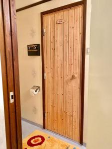 a wooden door in a room with a rug at Ferienhaus mit Sauna nah zum Bade- und Angelsee in Skruv +14 photos