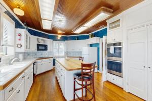 a kitchen with white cabinets and a wooden ceiling at Maverick Mountaintop Retreat in Canyon Lake