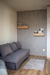 a living room with a couch and a striped wall at Mint Vibe Apartment in Odorheiu Secuiesc