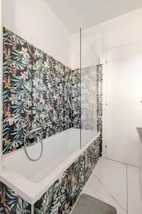 a bathroom with a floral patterned wall at Latina Modern Apartment in Latina