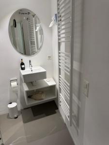 un bagno bianco con lavandino e specchio di Emelie a Thun