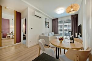 a living room and dining room with a table and chairs at Hotel LIDO in Jurata