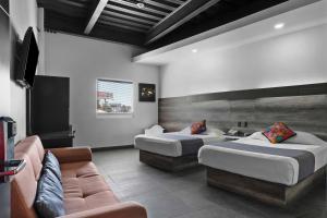 una habitación de hotel con dos camas y un sofá en Homesuites Malecon, en Culiacán