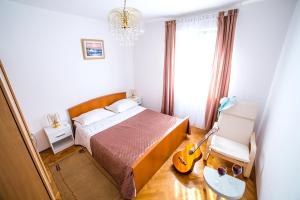 a bedroom with a bed and a guitar in it at Split Apartments Shell in Split