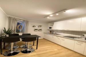 Una cocina con gabinetes blancos y una mesa y sillas. en Ferienwohnung, St Peter - Ording, en Sankt Peter-Ording