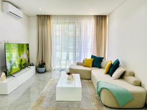 a living room with a couch and a tv at Blue Diamond Luxe-Setlhoa in Gaborone