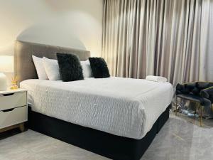 a bedroom with a large bed and a chair at Blue Diamond Luxe-Setlhoa in Gaborone