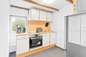 a kitchen with white cabinets and a refrigerator at DZ03 Praktische Monteurwohnung 6 Einzelbetten in Ditzingen