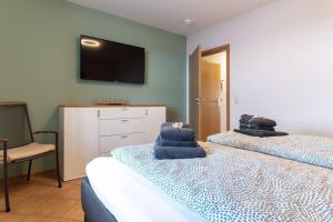 Un dormitorio con dos camas y un televisor en la pared. en Ferienwohnung in Büsum in traumhafter Lage, en Büsum