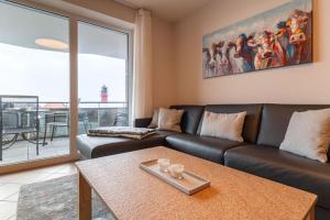 Una sala de estar con un sofá de cuero y una mesa. en Ferienwohnung in Büsum in traumhafter Lage, en Büsum