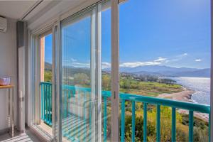 d'un balcon avec vue sur l'eau et les montagnes. dans l'établissement Studio Marine du Soleil, à Patrimonio