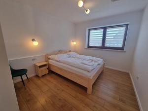 a bedroom with a bed and a desk and a window at Apartament u Ani in Ratułów