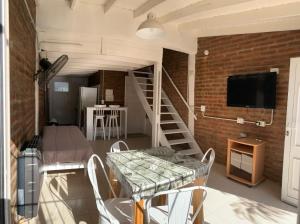a living room with a table and a brick wall at Depto Amonite Mar Caribe in Puerto Madryn