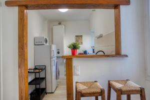 a kitchen with a counter and two stools in a room at 2 pièces, charmant, central, climatisé," Amorada " in Sarlat-la-Canéda +5 photos