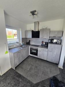 a kitchen with stainless steel appliances and a sink at Deichkieker in Butjadingen +23 photos