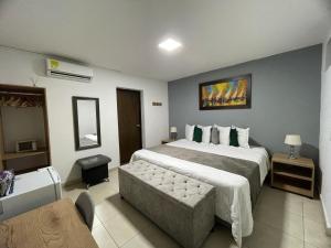 a hotel room with a large bed and a couch at Aguacatala Hotel Boutique in Medellín