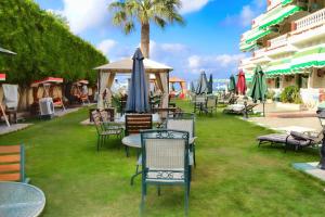 un grupo de sillas y mesas con sombrillas en el césped en Riviera Beach Chalets, en Marsa Matruh 11 fotos más