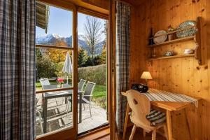 a wooden cabin with a table and a balcony with a view at Ferienwohnung Lauer in Schönau am Königssee