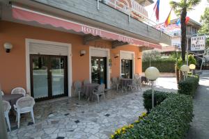 een restaurant met tafels en stoelen buiten een gebouw bij Hotel Olimpia in Sirmione