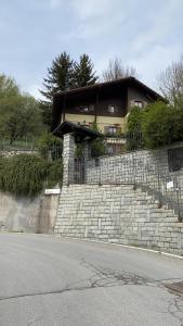 ein Haus auf einer Backsteinmauer in der Unterkunft Villa Avio in Temù