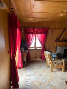 ein Wohnzimmer mit roten Vorhängen und einem Fenster in der Unterkunft Villa Avio in Temù