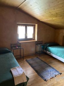 Zimmer mit 2 Betten, einem Fenster und einem Teppich in der Unterkunft Villa Avio in Temù